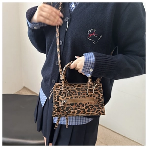 Dettaglio della borsa a tracolla leopardata che mostra dimensioni compatte e trama