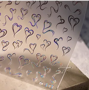 Gros plan d'autocollants pour ongles cœur holographiques avec relief 3D sur pierre