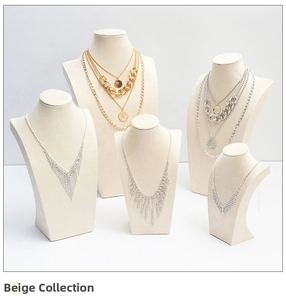 Detail of beige necklace display stands featuring layered gold and rhinestone jewelry pieces