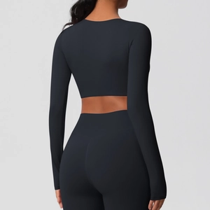Vue arrière d'un ensemble de fitness noir avec haut court à manches longues et legging