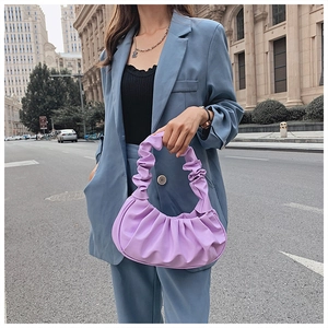 Close-up of a purple pleated handle bag featuring a cloud-shaped ruched design