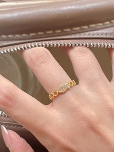 Detail of a 925 sterling silver gold fish ring with zircon stones worn on the finger