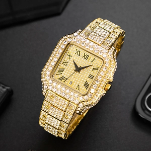 Close-up of gold iced-out square watch with Roman numerals and calendar display detail
