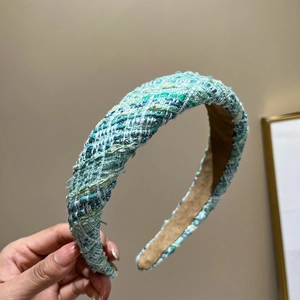 Detailed close-up of the woven tweed fabric texture on a padded headband for women