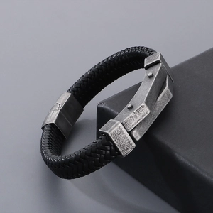 Close-up of black braided leather men's bracelet with vintage silver rivet metal clasp