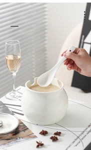 Detail of white ceramic seasoning jar with smooth glaze and matching ceramic spoon