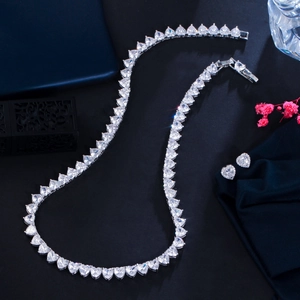 Close-up of heart-shaped zircon necklace and stud earrings set on black background
