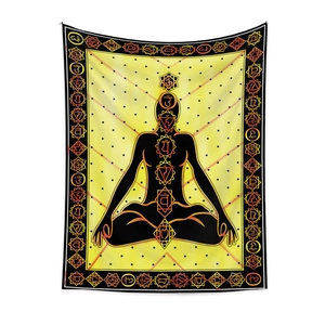 Macro shot of bohemian tapestry featuring seven chakras on a yellow meditation silhouette