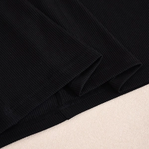 Gros plan sur le tissu en maille côtelée noire montrant la couture et la texture