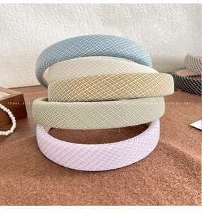 Detail of five colorful sponge headbands with woven texture in blue, beige, and pink