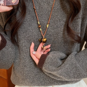 Detailed view of tiger eye stone gourd pendant on a long retro ethnic style necklace