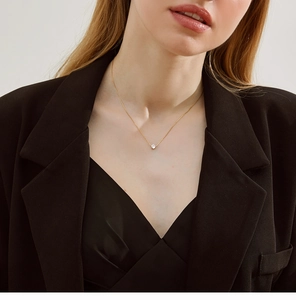 Close-up of a sparkling zircon solitaire pendant on a 18K gold-plated bamboo chain link