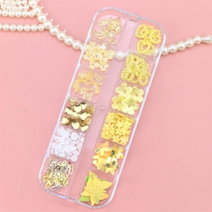 Macro view of 12-grid storage box with gold and white butterfly nail art charms