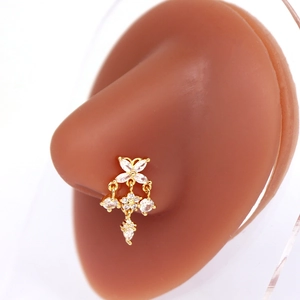 Vue rapprochée d'un piercing de nez doré avec pendentifs fleurs et papillons