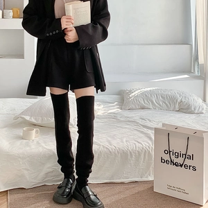 Cozy black knitted over-the-knee leg warmers worn in a warm indoor home setting