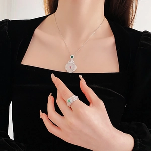 Detail shot of zircon pendant necklace and ring with white jade in silver finish