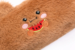 Close-up of soft brown plush pencil case featuring cute cartoon watermelon embroidery