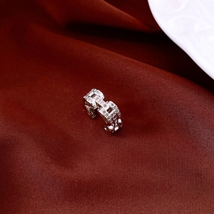 Macro shot of silver ear cuff with micro-pave cubic zirconia on red velvet fabric