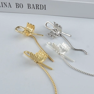 Minimalist metallic knot ear cuffs with long chains in gold and silver finishes