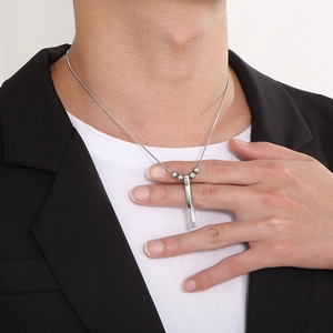 Detail view of men's stainless steel necklace with spiral bar pendant on a male model