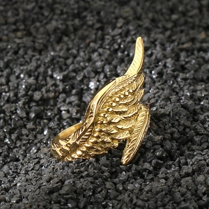 Detailed macro shot of vintage gold wing ring showing intricate feather textures on black stone