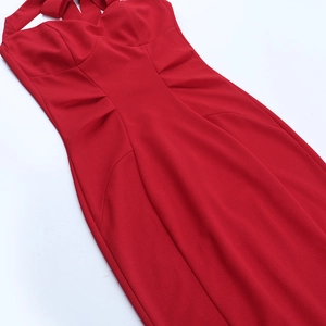 Detail of red deep V-neck halter dress showing slim fit ruching and stretch fabric texture
