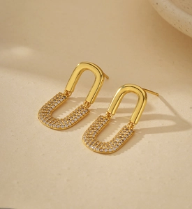 Macro detail of gold U-shaped earrings with micro-pave cubic zirconia setting