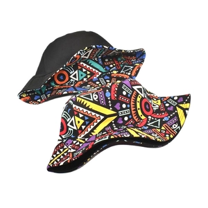 Close-up of reversible bucket hat showing black side and colorful geometric tribal prints