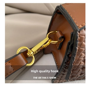 Close-up of brown woven texture on cross-body bag with high-gloss gold hardware