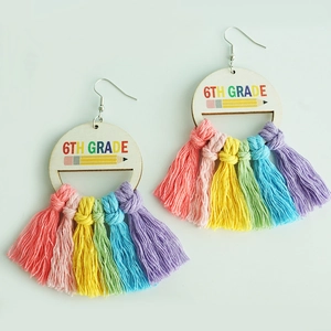 Detail of 6th Grade rainbow tassel wooden earrings with pencil design on white background