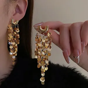 Élégantes boucles d'oreilles dorées en U avec des paillettes rondes et des glands