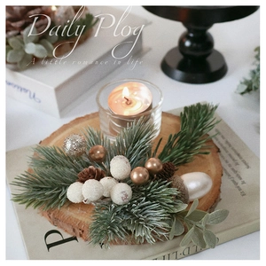 Rustic Christmas candle holder detail with pine needles, berries and log base decor
