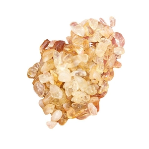 Polished yellow and orange natural crystal crushed stones on a white background
