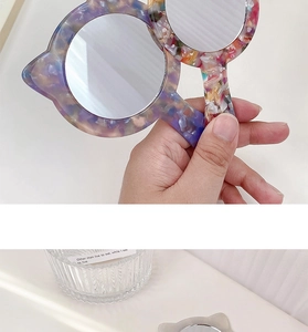 Detail of cute cat-shaped acetate handheld makeup mirrors with unique textured patterns
