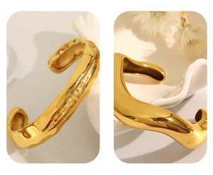 Macro shot of gold cuff bracelet featuring irregular lava texture and metallic glossy finish
