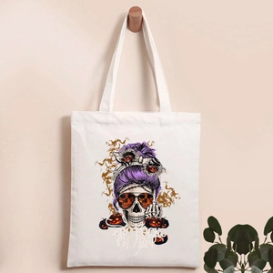 Detail of canvas tote bag featuring Halloween skeleton pumpkin print and bold slogan text