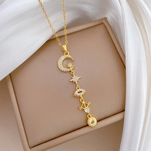 Elegant gold celestial necklace with moon, star, and evil eye charms on silk fabric