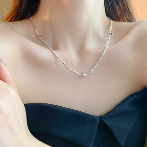 Detail of silver smiley face pendant necklace worn on neck for a stylish look