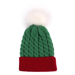 Close-up of green and red knit Christmas hat with soft white pom-pom detail