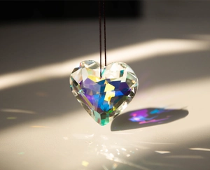 Macro detail of heart-shaped crystal prism pendant showing vibrant rainbow light reflections
