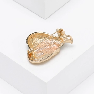 Detailed back view showing the gold metal pin clasp structure of the avocado brooch