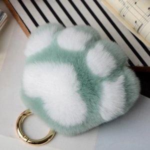Detailed shot of mint green and white plush kitten paw keychain with gold ring