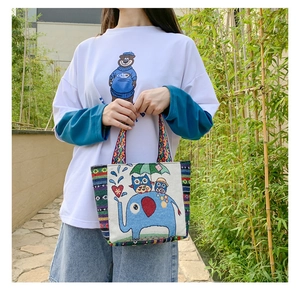Close-up of bohemian canvas tote bag with elephant embroidery and woven handles