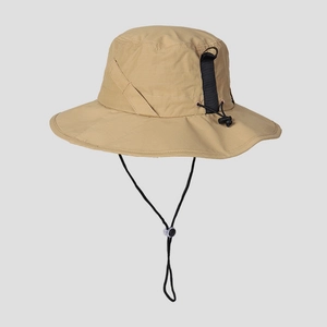 Detail of beige outdoor sun hat with black nylon strap, D-ring, and adjustable chin cord