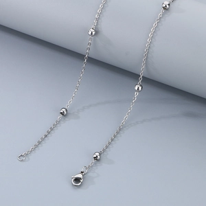 Detail of silver stainless steel satellite chain with small beads and lobster clasp
