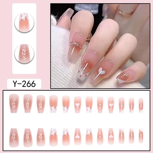 Vue détaillée de faux ongles dégradé rose avec motifs de cœur et d'argent brillant.