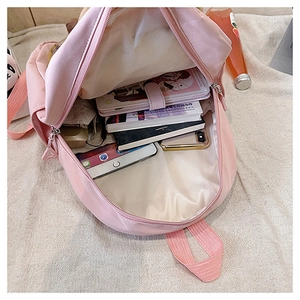 Internal view of pink canvas backpack showing large capacity for books and phone