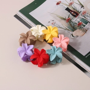 Matte flower hair claws in multiple colors arranged on a minimalist background