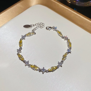 Detail of silver bracelet with yellow marquise and white square zircons and lobster clasp