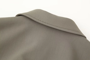 Detailed close-up of taupe bomber jacket collar showing premium stitching and fabric texture